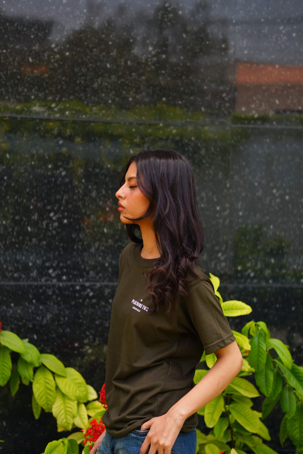 Girl wearing essentials blend army green t-shirt looking to her right.