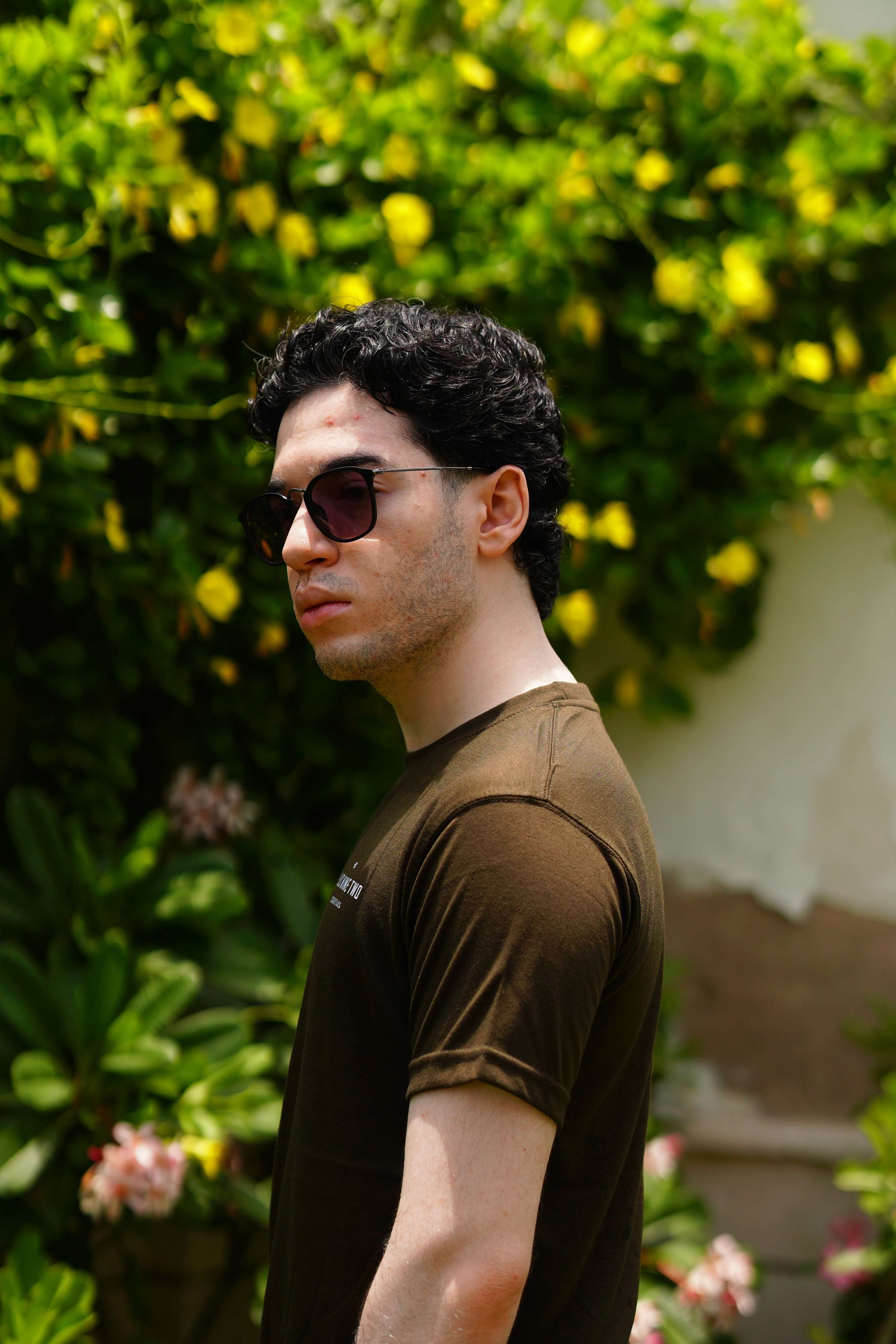 Man posing and looking away from camera wearing plus92 clothing essentials blend t-shirt in army green