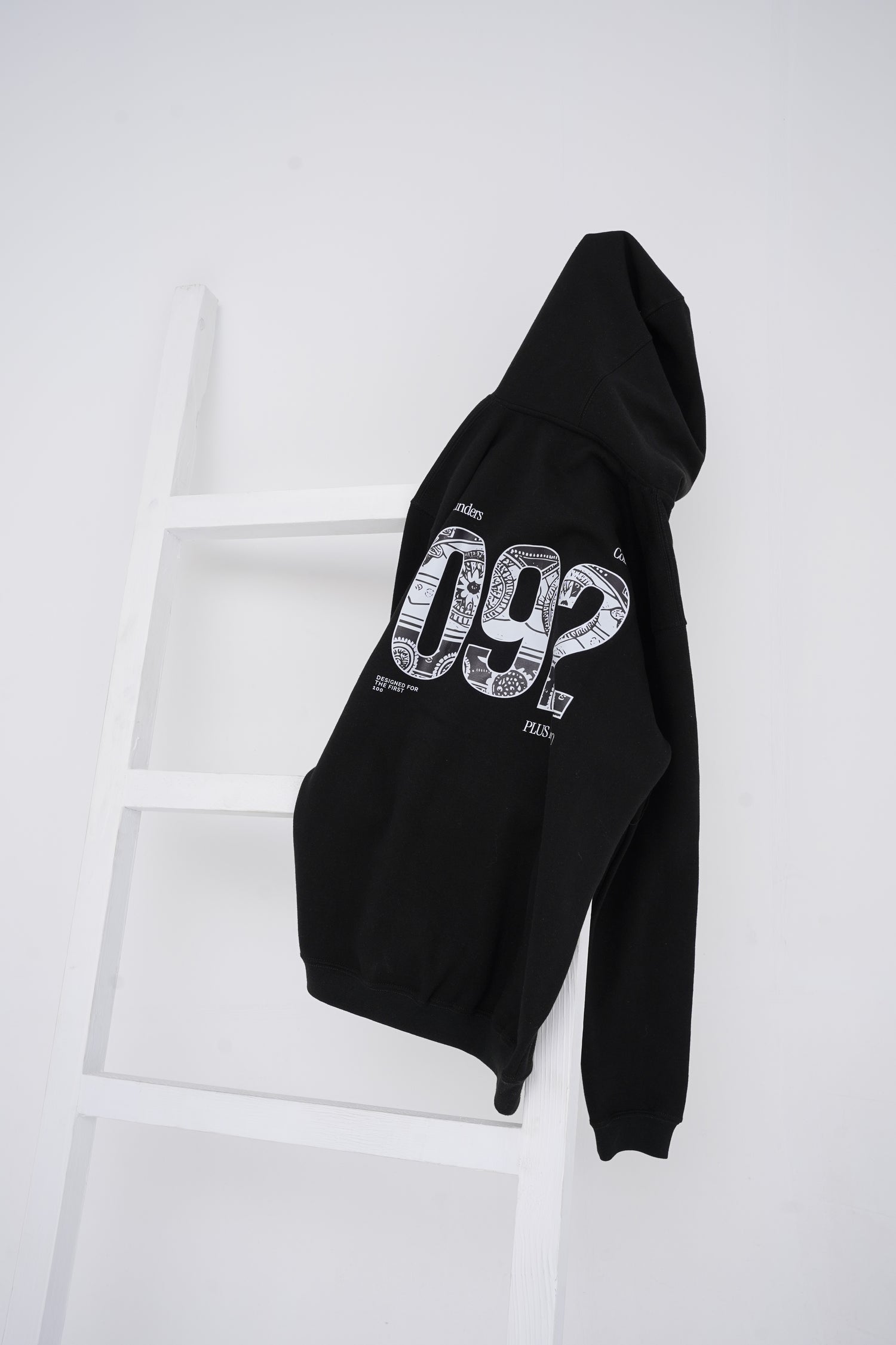 Black Hoodie with 092 on the back hanging of a chair