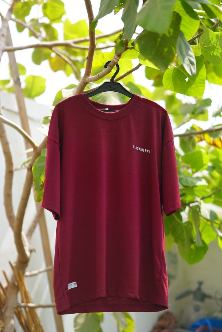 Ajrak Maroon Essentials Dropshirt men’s oversized t-shirt hanging outdoors by +92 Clothing