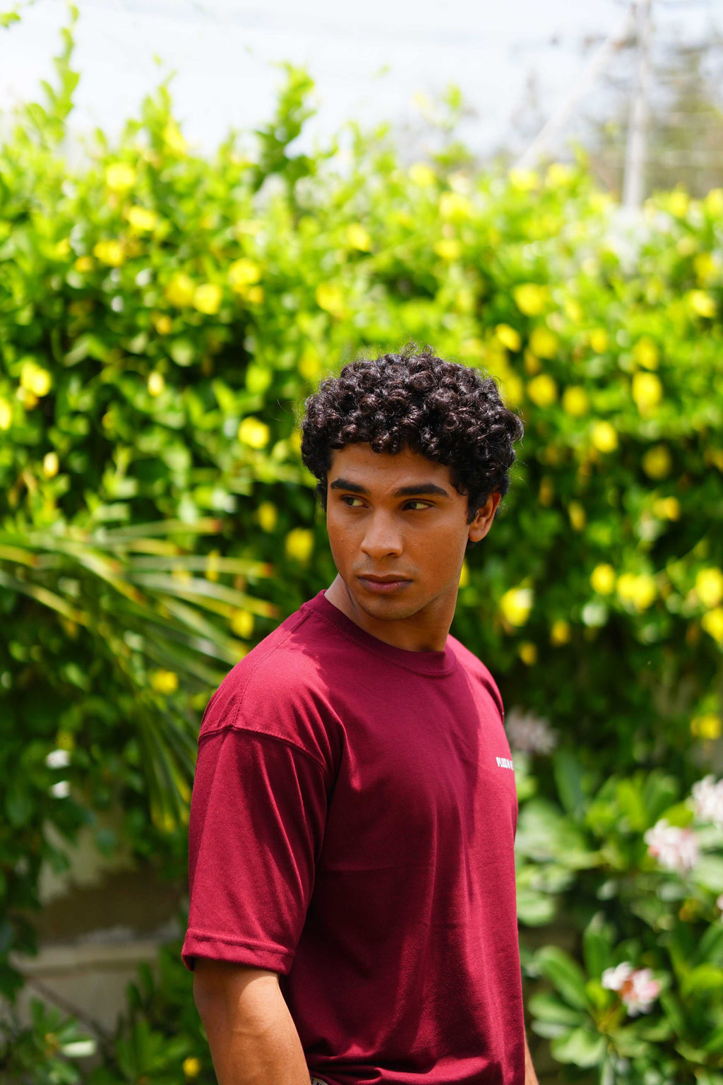 Male model wearing Ajrak Maroon Essentials Dropshirt men’s oversized t-shirt outdoors