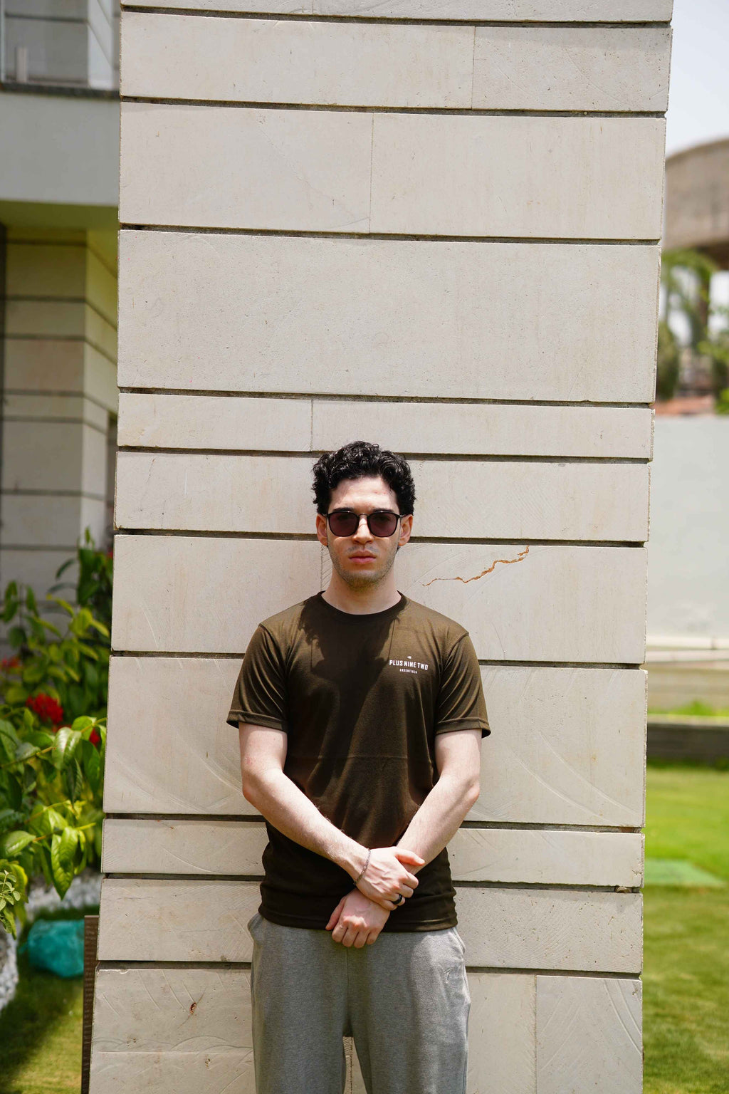 Men’s Army Green Essentials Blend T-Shirt front view against a stone wall