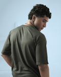 Man facing opposite wearing essentials army green oversized t-shirt by Plus92 Clothing.
