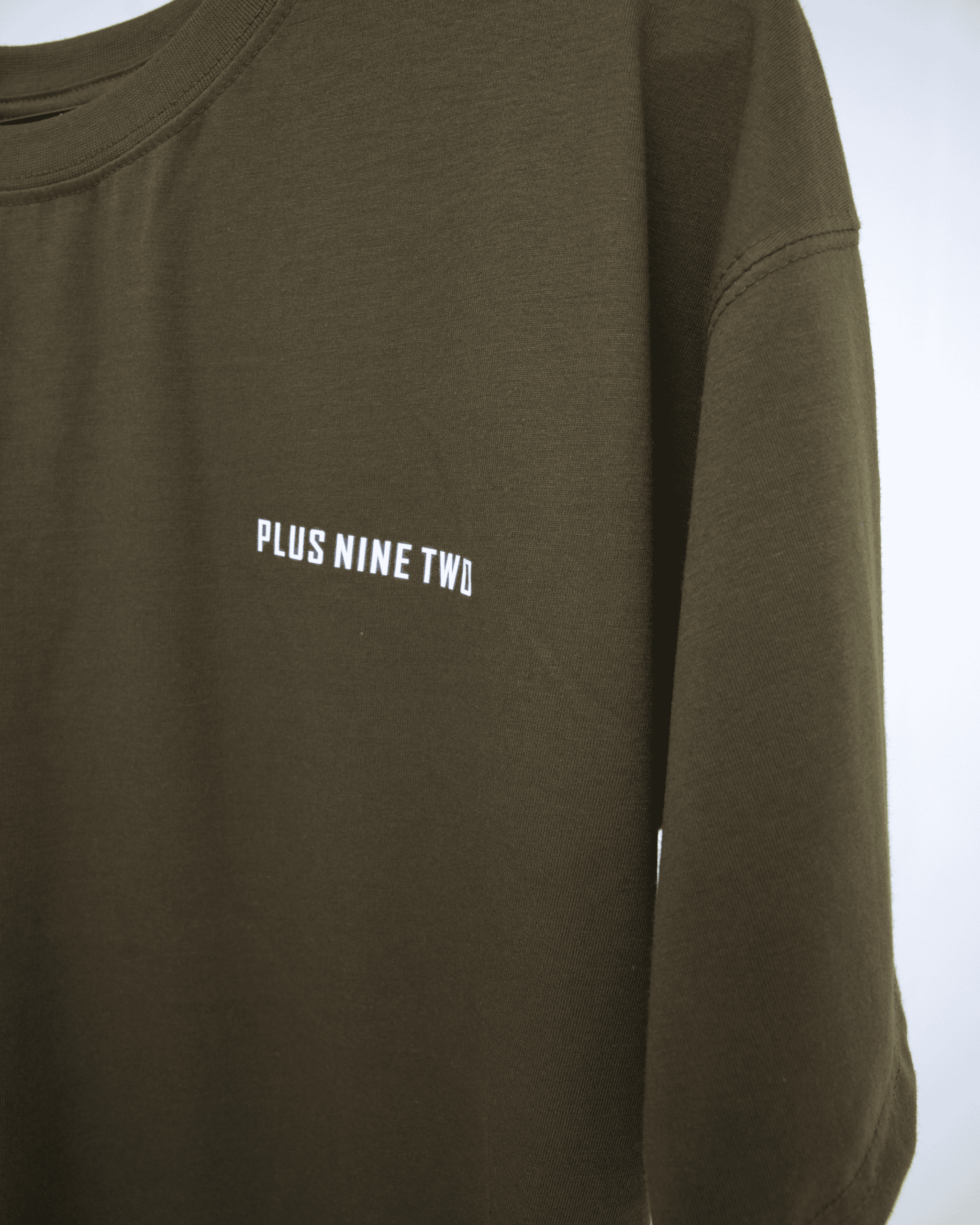Army Green oversized t-shirt with 'PLUS NINE TWO' text on a white background