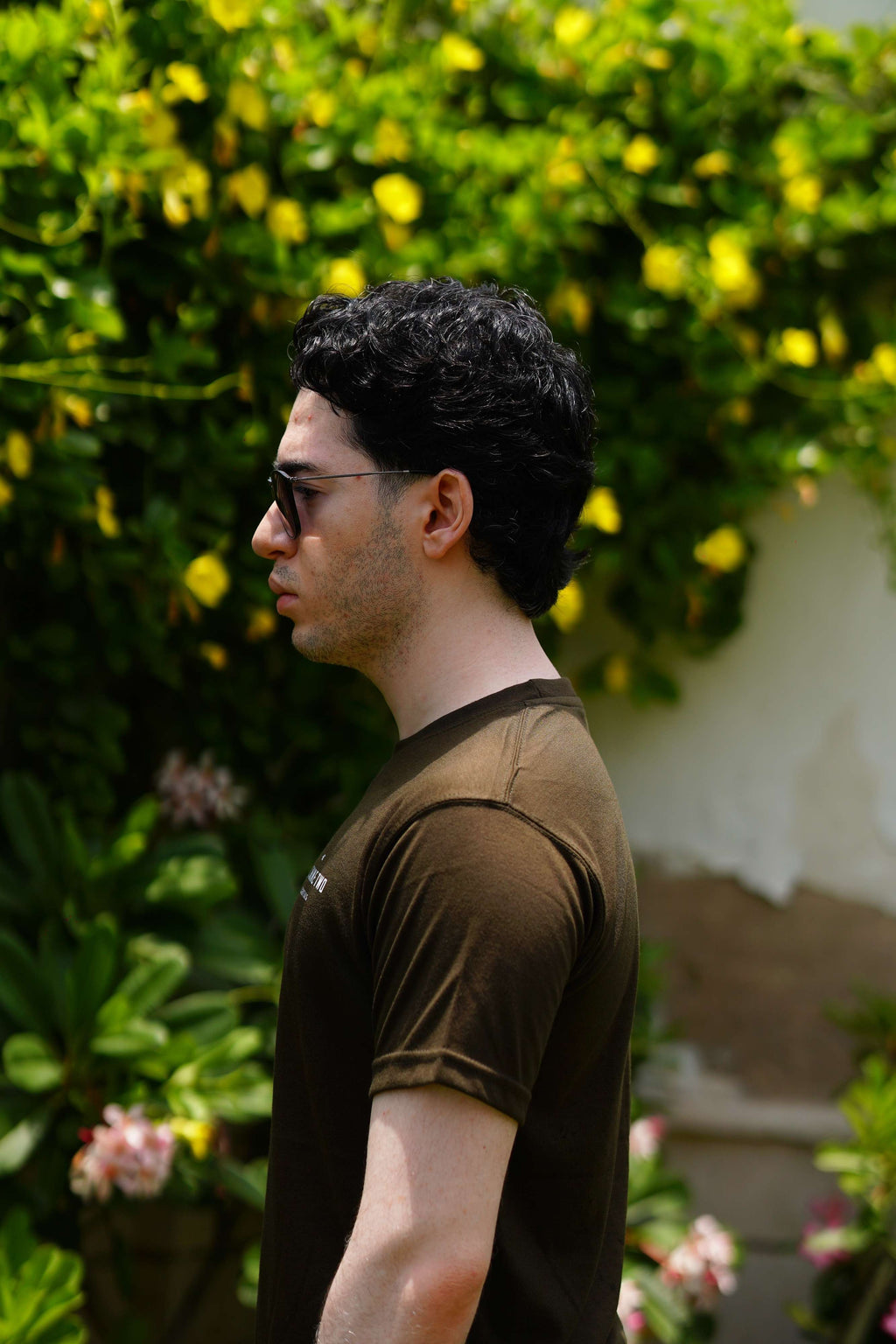 Men’s Army Green Essentials Blend T-Shirt side profile in outdoor garden setting
