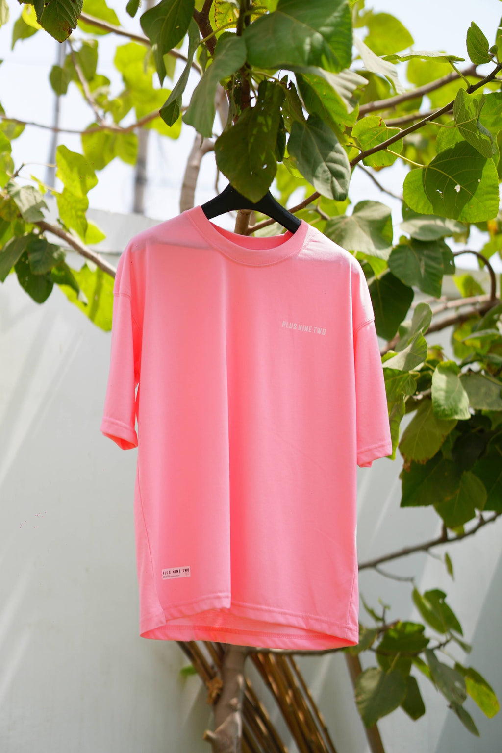 Baby Pink Essentials Dropshirt hanging on tree branch product photo