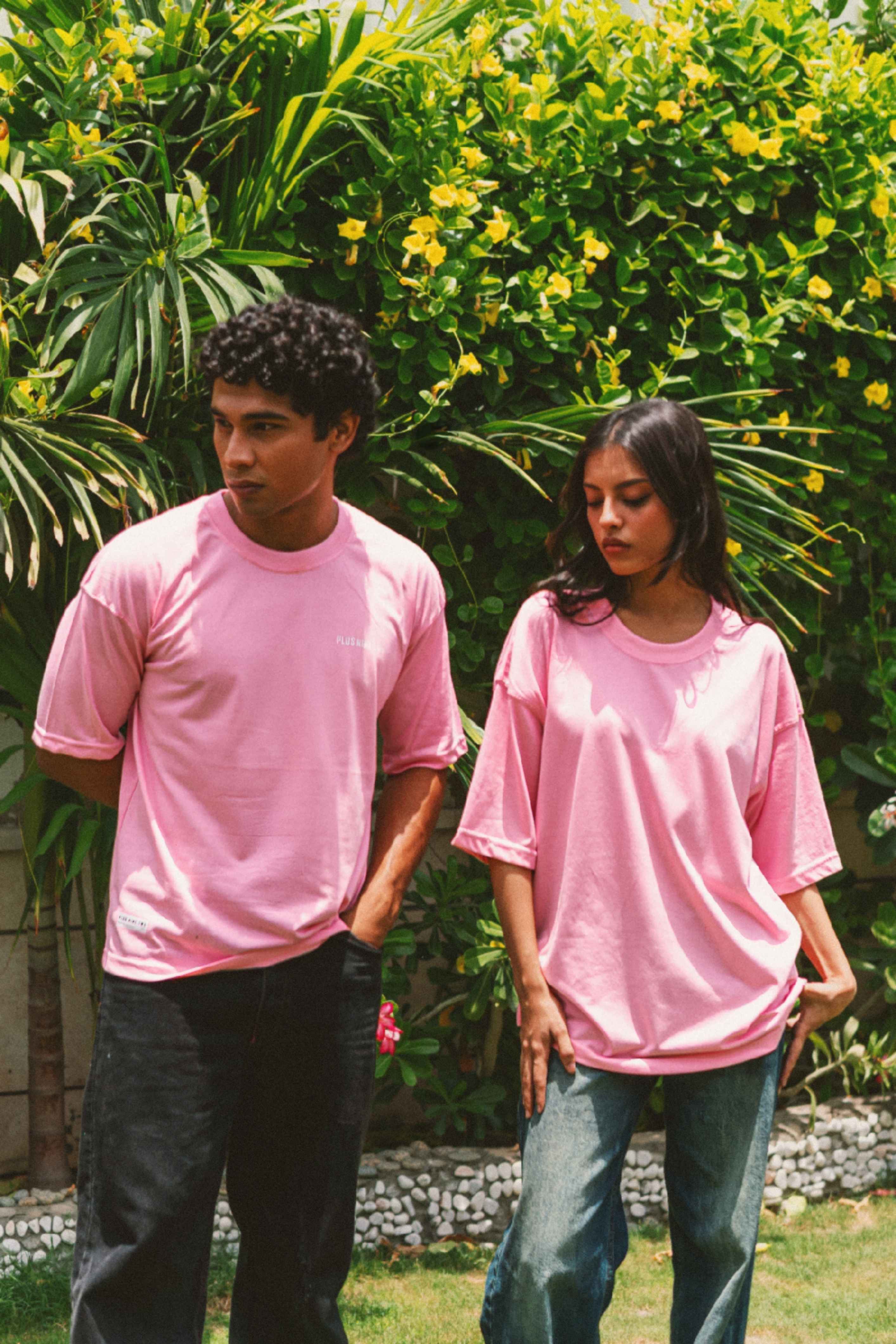 Men and women wearing Baby Pink Essentials Dropshirts in outdoor garden photoshoot