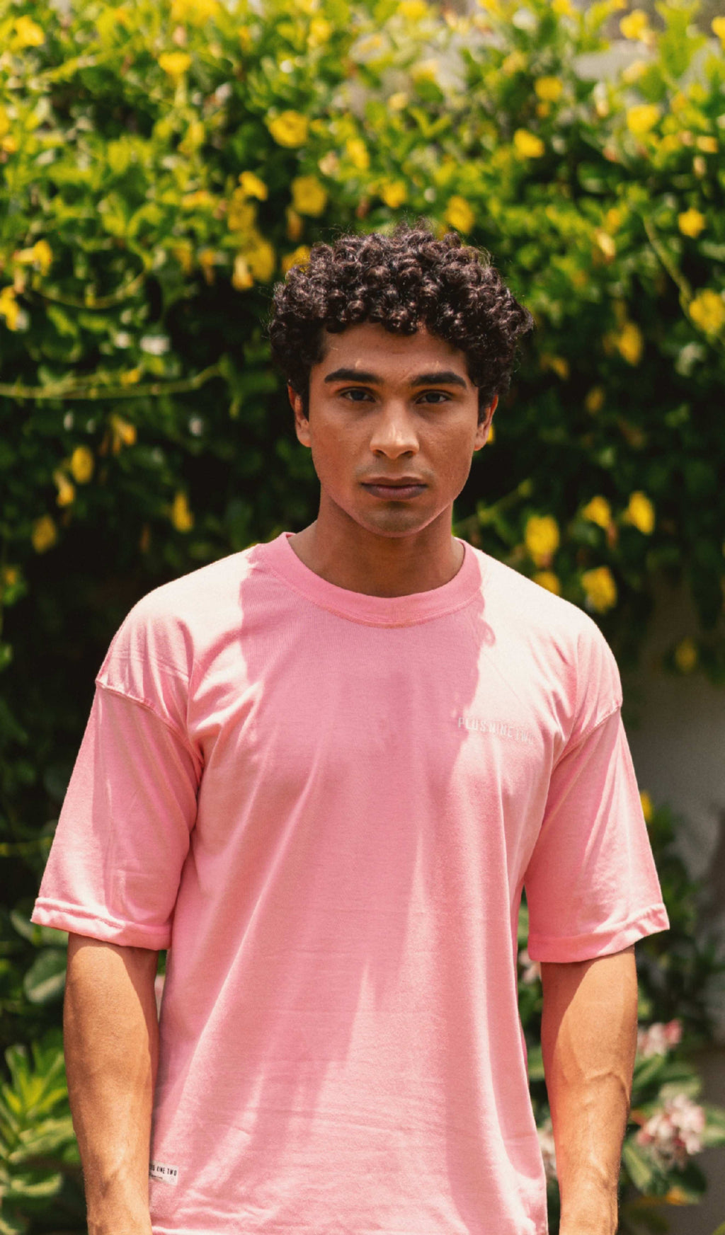 Men’s Baby Pink Essentials Dropshirt front view in garden photoshoot