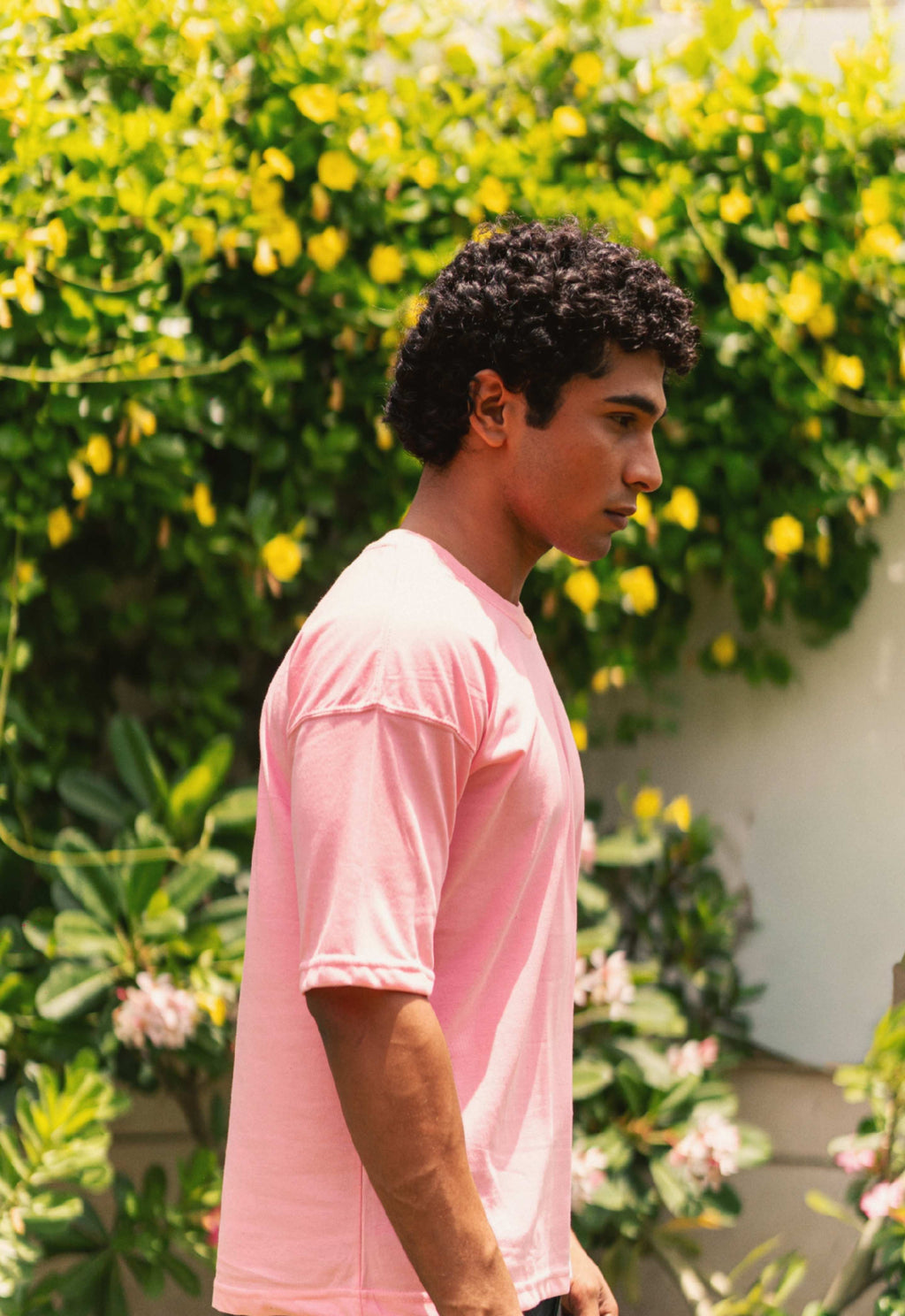 Men’s Baby Pink Essentials Dropshirt side profile in outdoor greenery