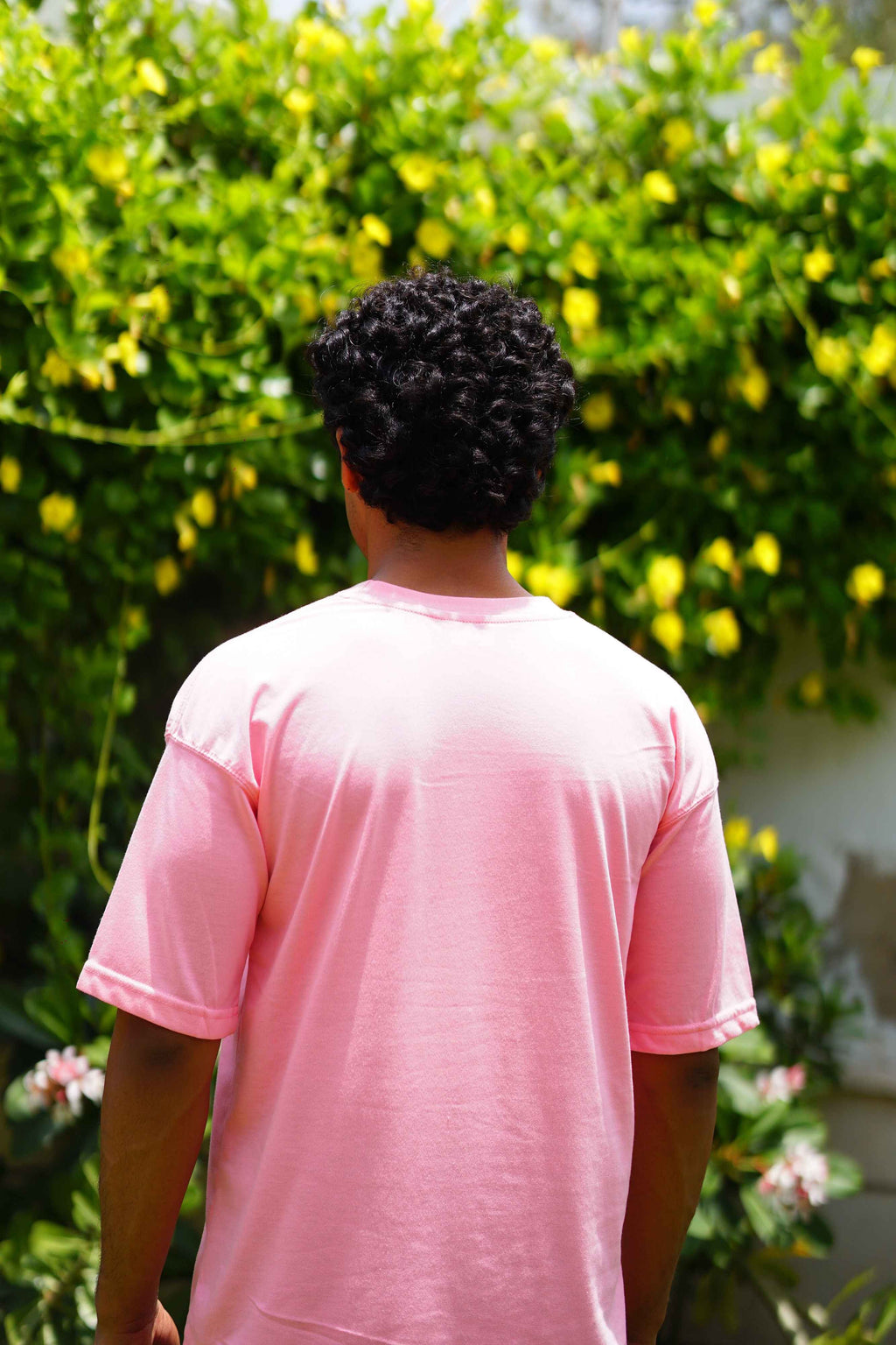 Back view of Men’s Baby Pink Essentials Dropshirt outdoors