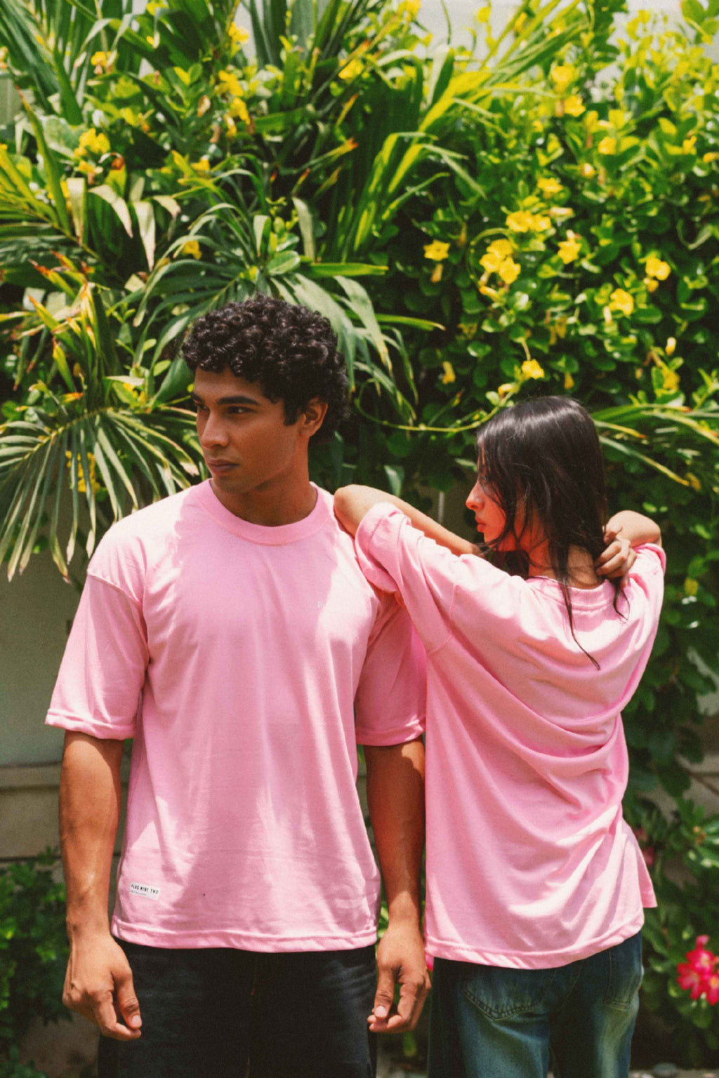Men and women wearing Baby Pink Essentials Dropshirts in matching outdoor shoot