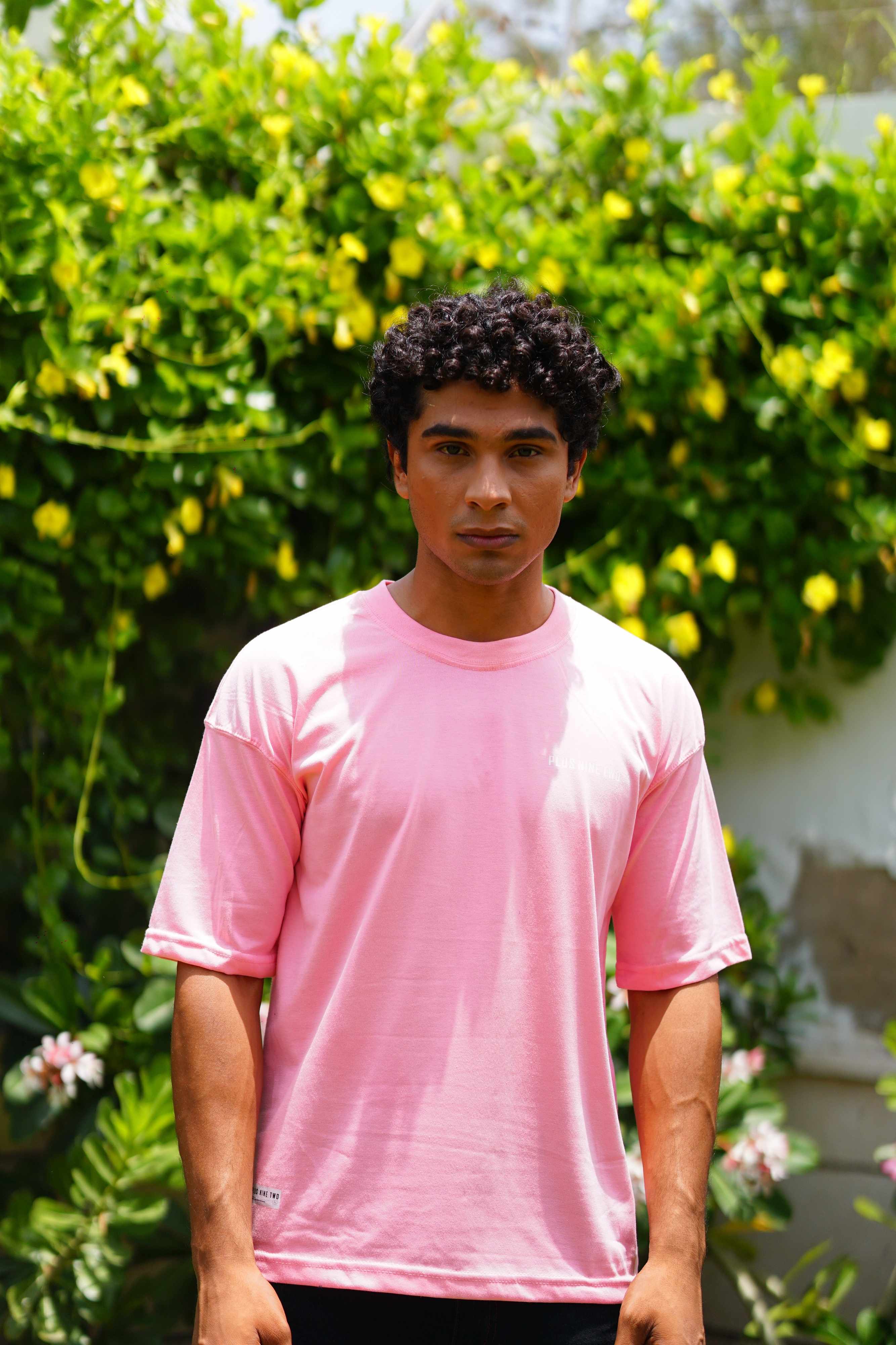 Front view of male model wearing Baby Pink Essentials Dropshirt men’s oversized t-shirt