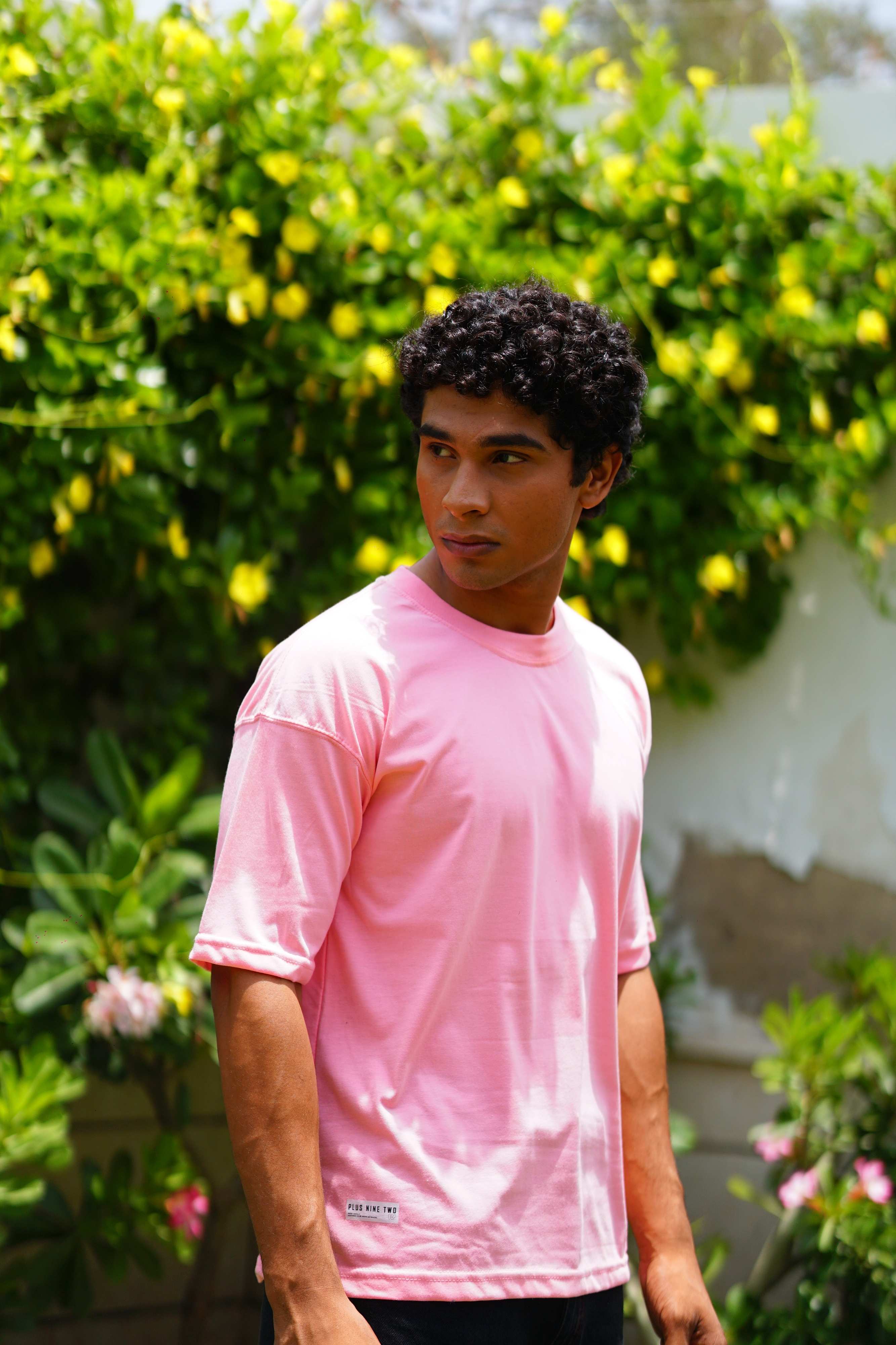 Male model wearing Baby Pink Essentials Dropshirt for men in outdoor lifestyle shot