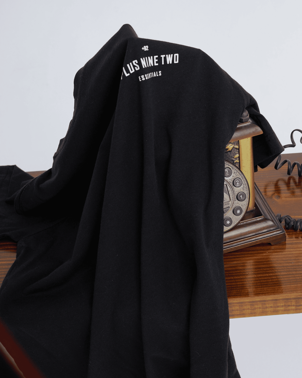 Black t-shirt with text on a wooden surface