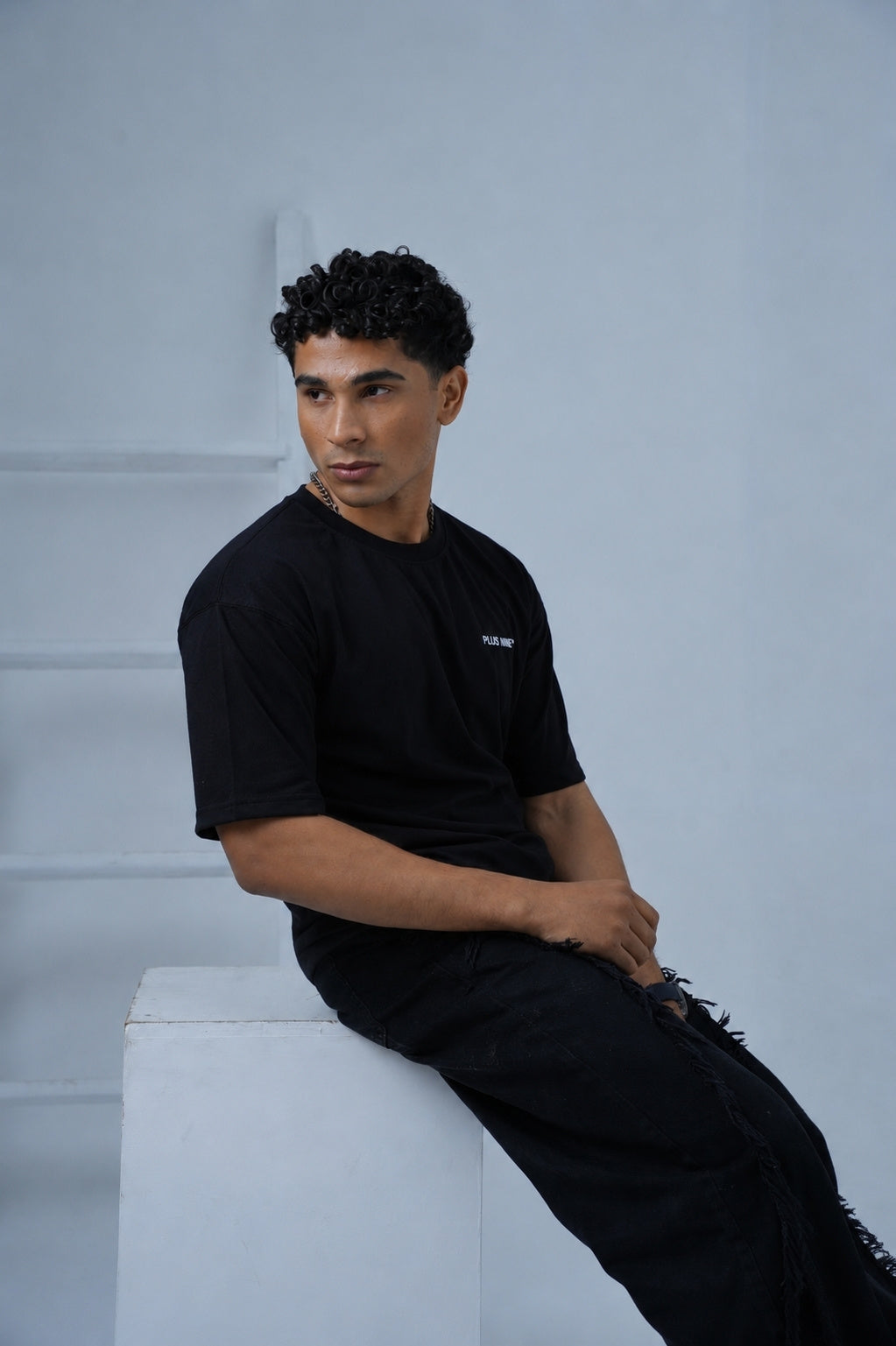 Male model sitting in Black Essentials Dropshirt men’s oversized t-shirt with Plus Nine Two logo