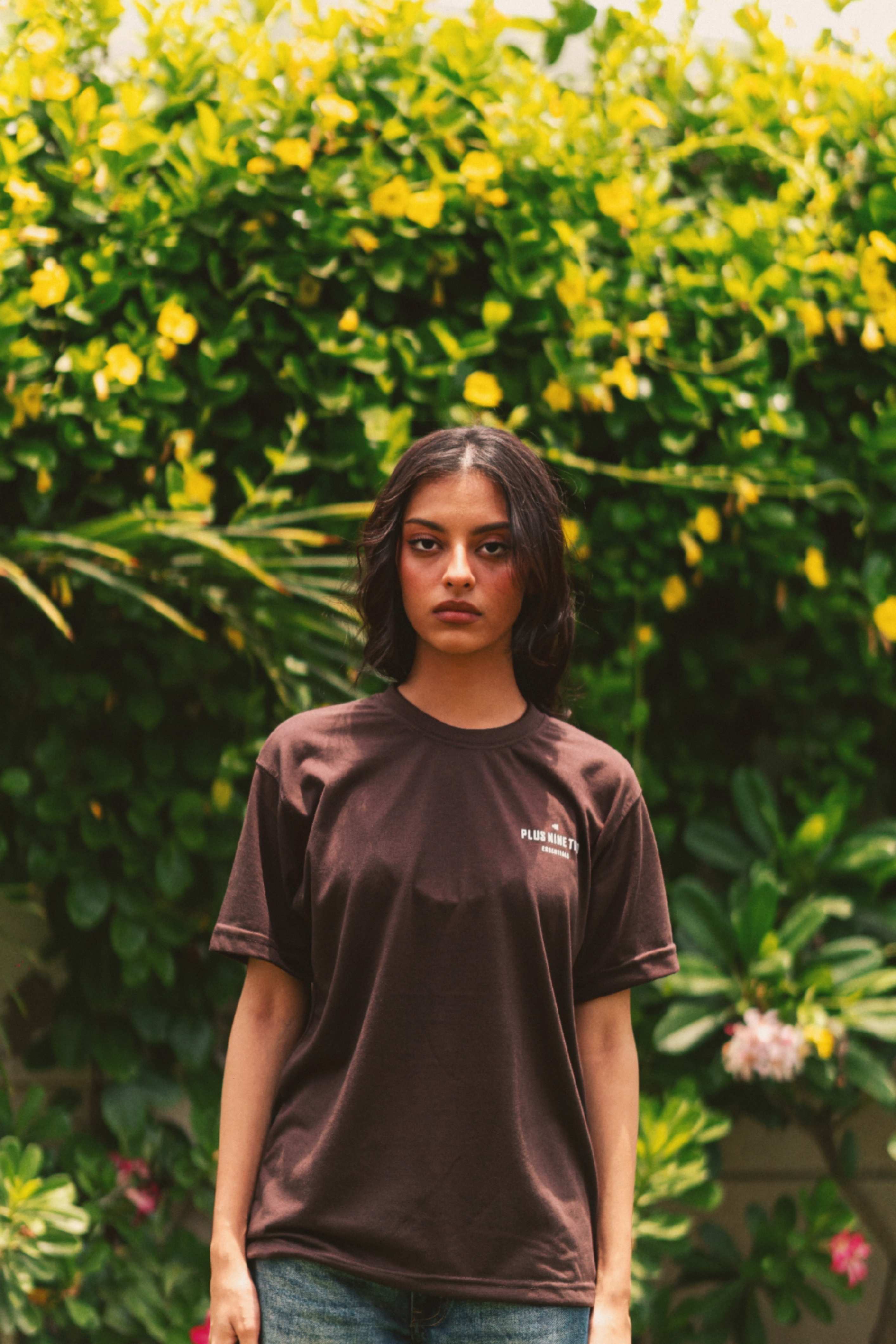 Front view of Women’s Karak Brown Essentials Blend T-Shirt in garden photoshoot
