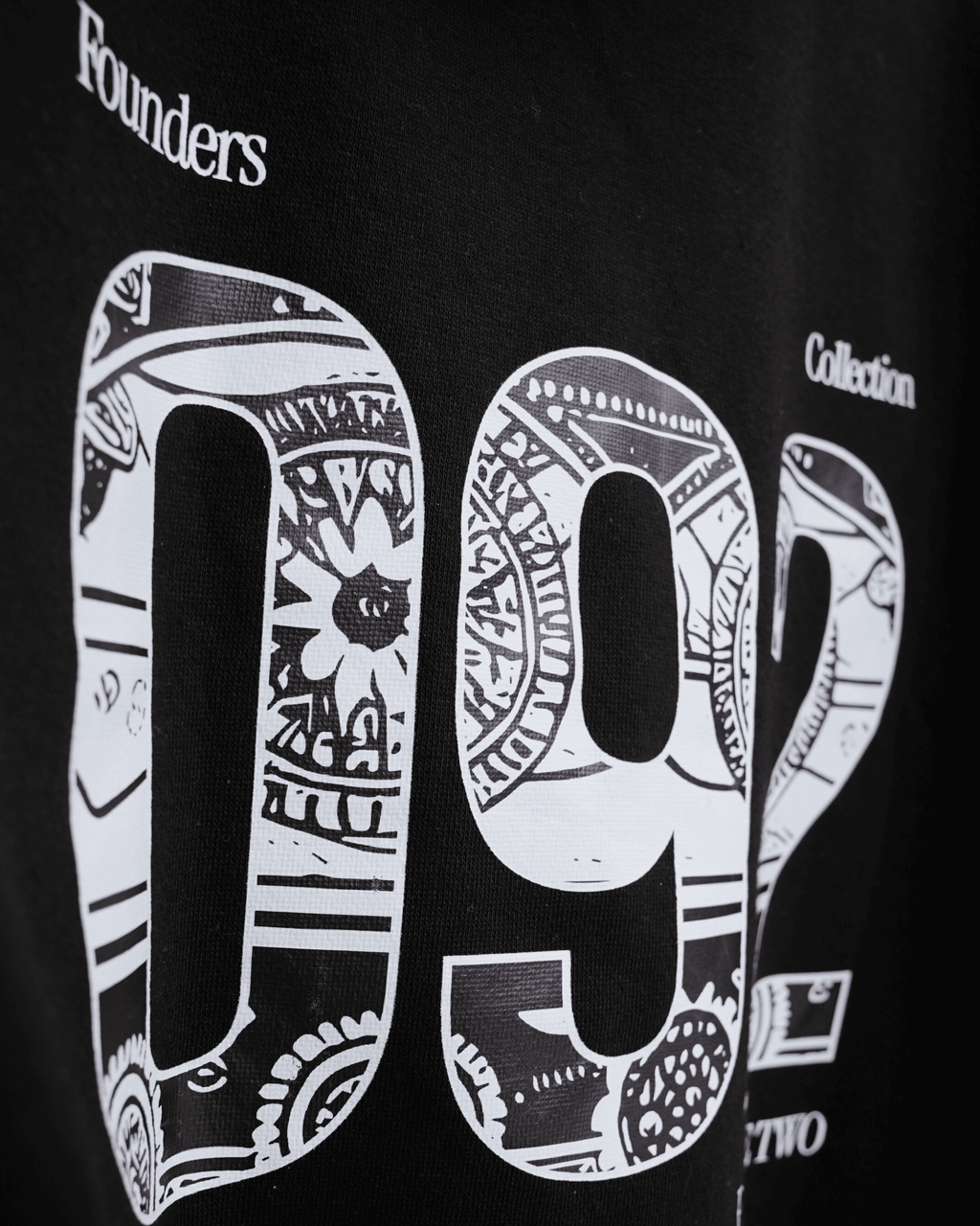 Black hoodie with white patterned numbers '092' inspired by truck art and text saying 'Founders Collection'