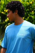 Close-up of male model wearing K2 Cloud sky blue Essentials Dropshirt with Plus Nine Two logo