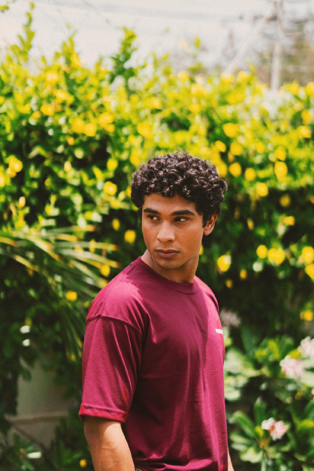 Three-quarter view of a male model wearing the Ajrak Maroon Men's Essentials Drop Shirt, highlighting the premium drape of the fabric.
