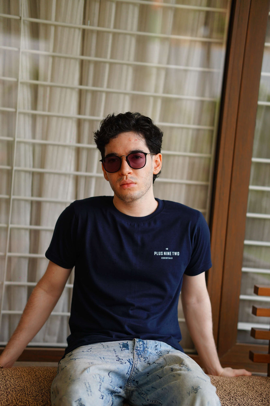 man wearing essentials indus navy blue men blend t-shirt while sitting and looking to the camera