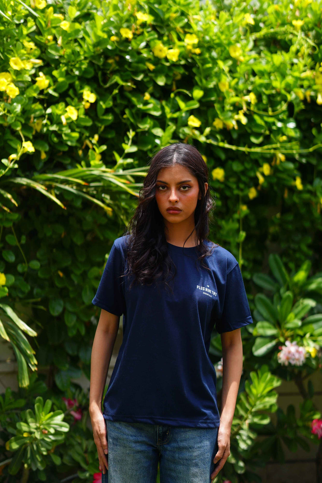 Girl wearing essentials indus navy blue blend t-shirt looking towards the camera.