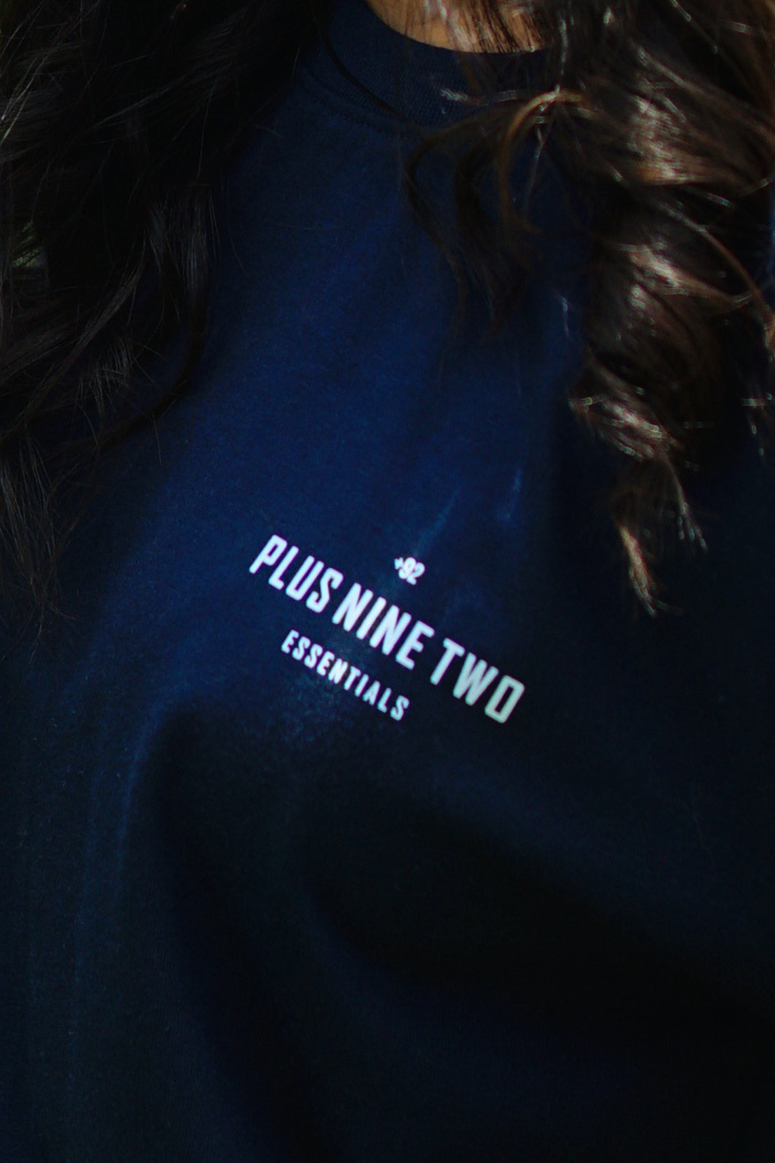 Girl wearing essentials indus navy blue blend t-shirt closeup on pocket print.