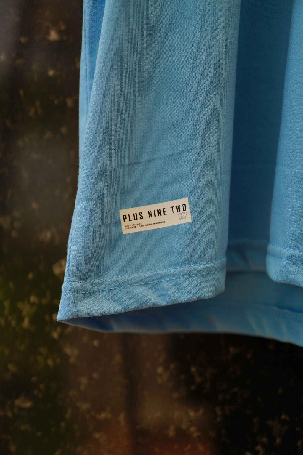 Close-up of K2 Cloud Sky Blue Essentials Dropshirt hem label detail