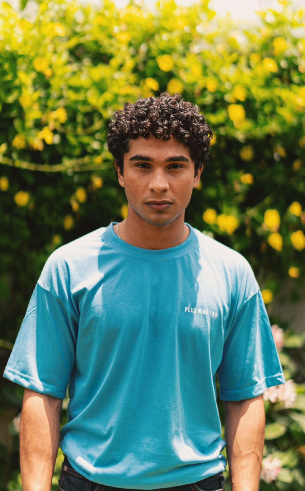 Men’s K2 Cloud Sky Blue Essentials Dropshirt front view in garden photoshoot