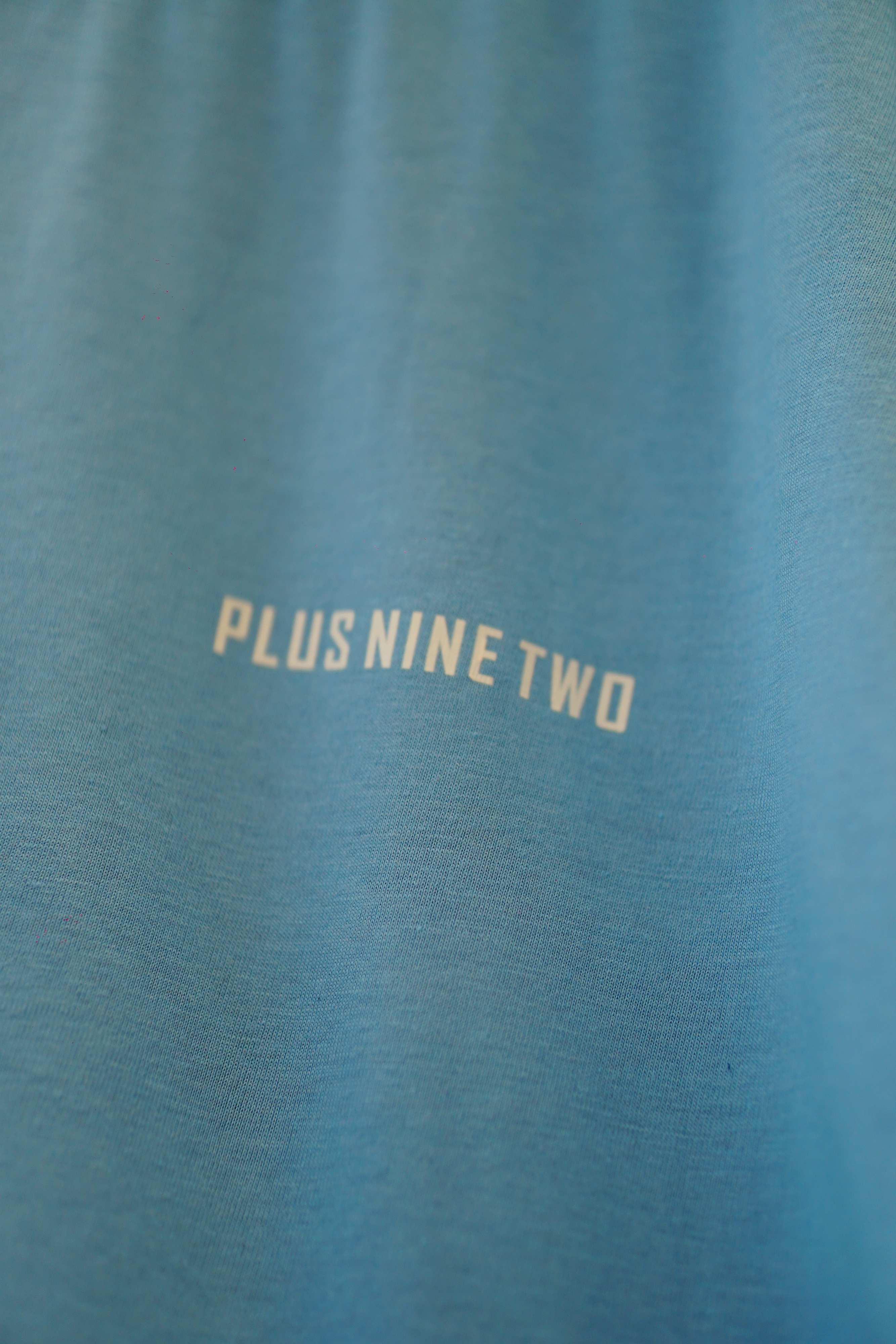 Close-up of K2 Cloud Sky Blue Dropshirt fabric and Plus Nine Two logo