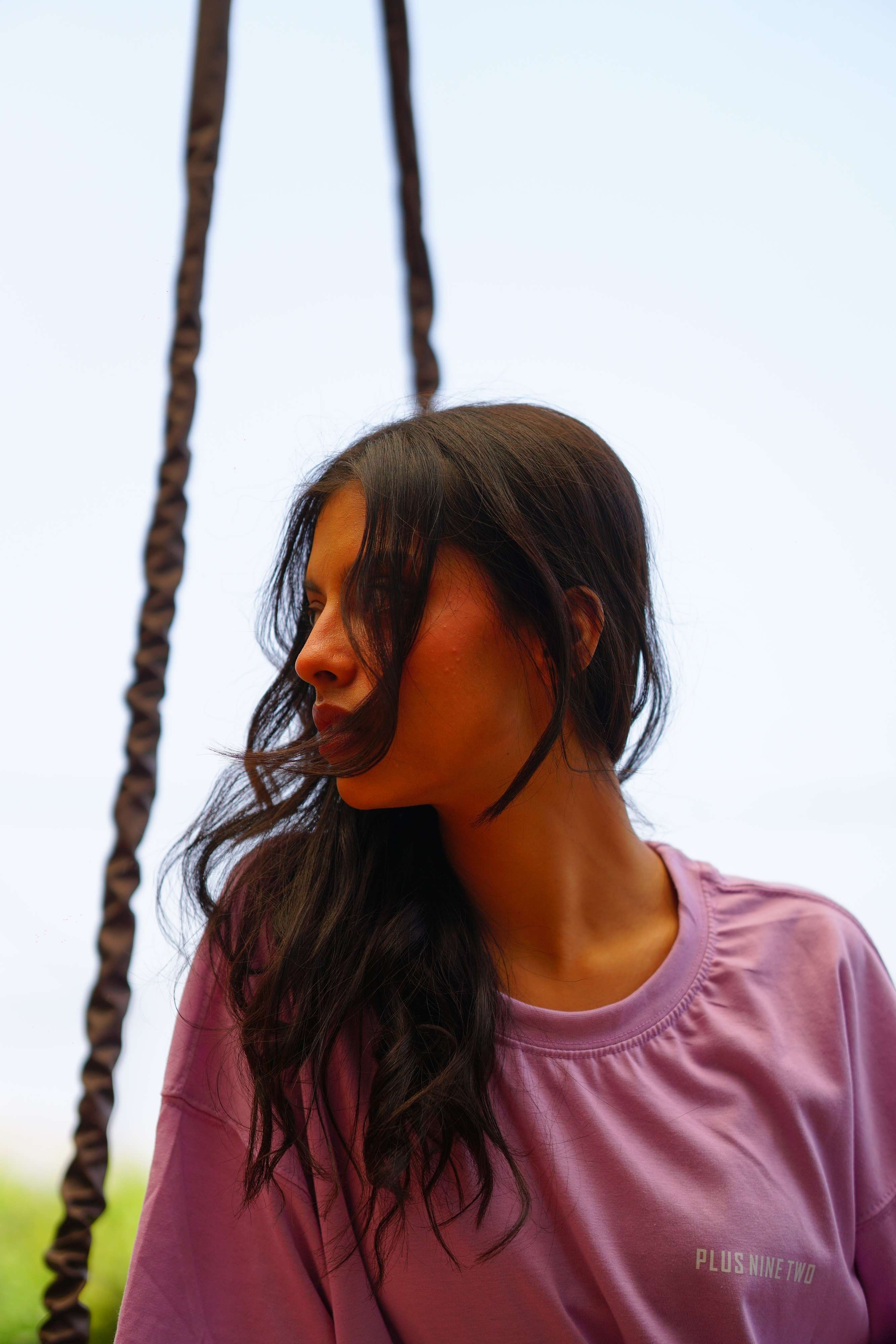 women wearing lahore lilac plus92 essentials dropshirt while sitting on a bench.