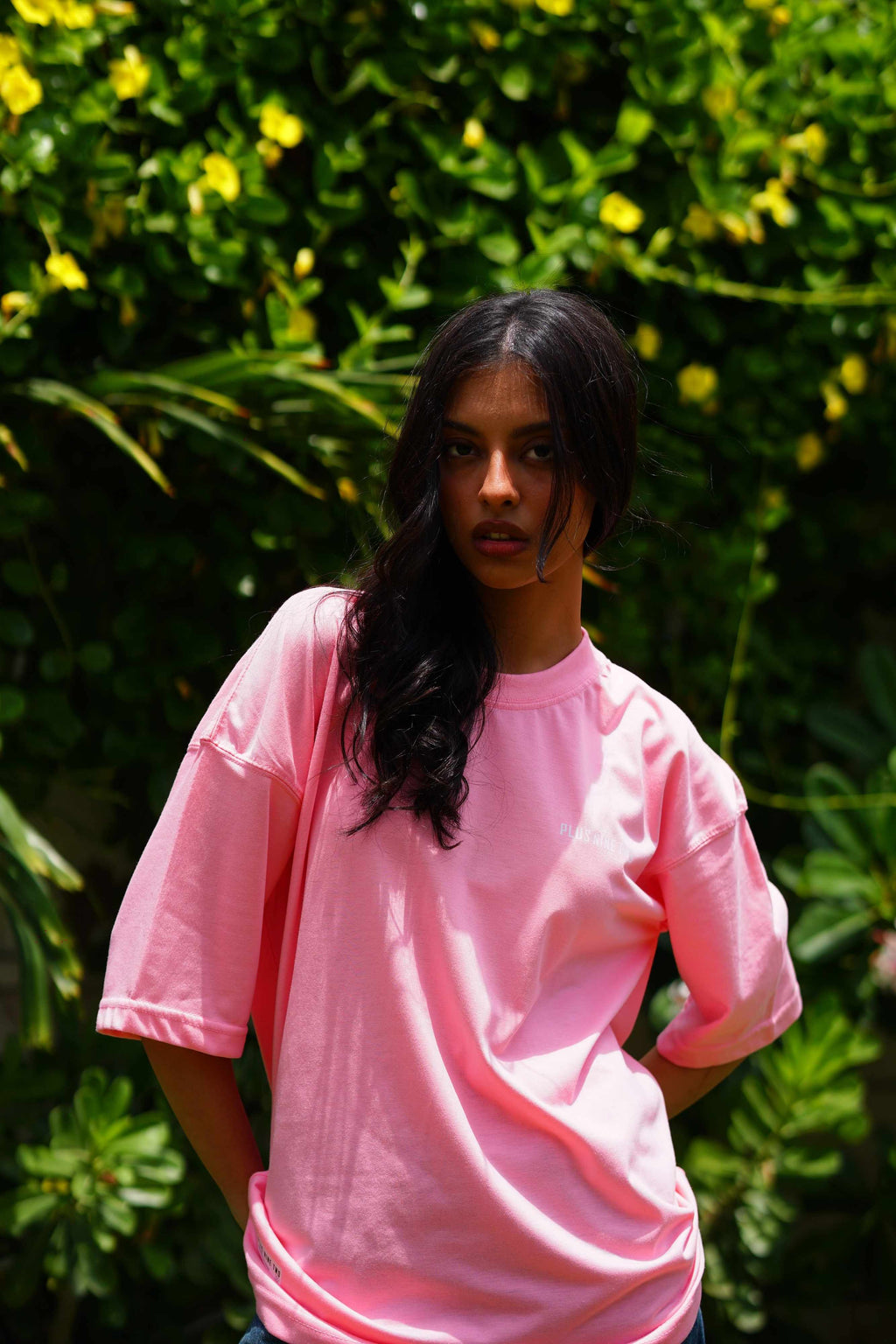 Female model wearing Baby Pink Essentials Dropshirt women’s oversized t-shirt outdoors