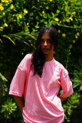 Female model wearing Baby Pink Essentials Dropshirt women’s oversized t-shirt outdoors