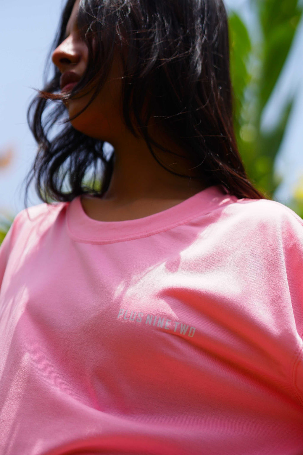 Close-up lifestyle shot of female model wearing Baby Pink Plus Nine Two Dropshirt